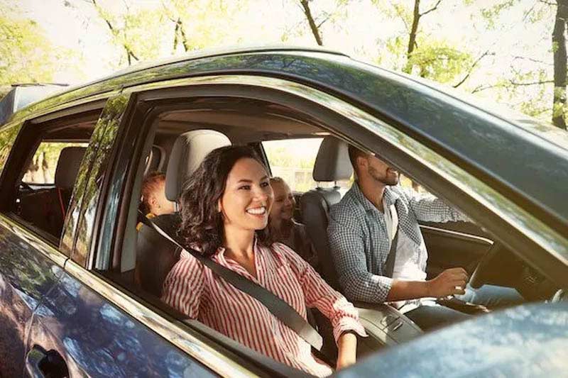 A family of four is happily driving in a car
